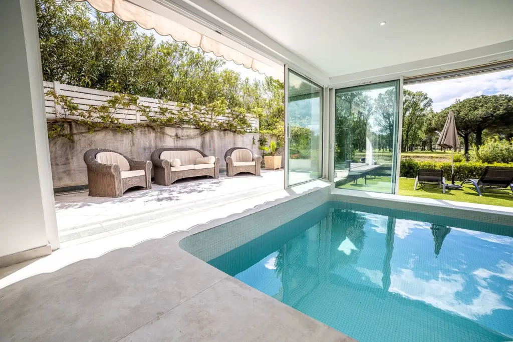 Piscine intérieure et terrasse ombragée de la villa de luxe à La Grande Motte avec vue sur le golf